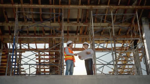 エンジニアと建築家は 建設現場でお互いを祝福する手を振る — ストック動画