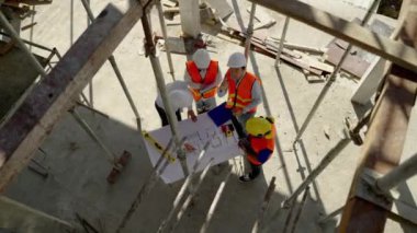 Üst köşe, inşaat mühendisliği ekibi mimar ve ustabaşıyla birlikte Blue Print 'i izliyor ve inşaat alanının inşaatını planlıyor..