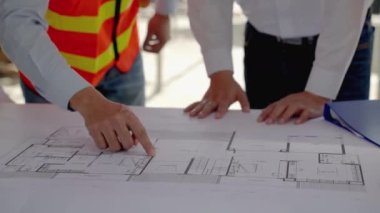 İnşaat mühendisliği ekibi, mimar ve ustabaşı ile birlikte Blue Print 'i izliyor ve inşaat alanının inşasını planlıyor..