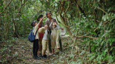 Asyalı bayan öğretmenler, gerçek yerlerden, eğitici kavramlardan, maceralardan doğayı incelemek için öğrencileri doğa gezisine çıkarıyorlar..