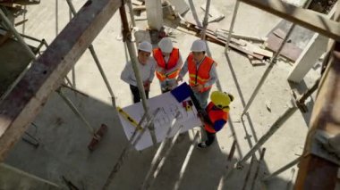 Üst köşe, inşaat mühendisliği ekibi mimar ve ustabaşıyla birlikte Blue Print 'i izliyor ve inşaat alanının inşaatını planlıyor..