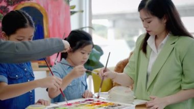 Öğretmen özel okulda öğrencilere öğretmenlik yapıyor, Asyalı çocuklara sanatın temellerini öğretiyor..