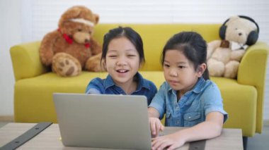 İki Asyalı kız İnternet 'ten öğrenim görüyor, Ev Çalışması, Sosyal Mesafe, E-Öğrenim.