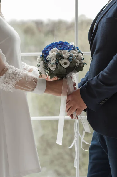 Wedding couple holding hands and holding bridal flower — 图库照片