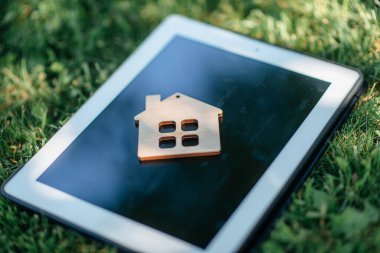 Yeşil çimenlikteki biblo ev, emlak hizmetleri kavramı