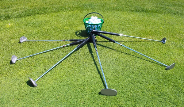 Järn golfklubbor och golfbollar på grönt gräs — Stockfoto
