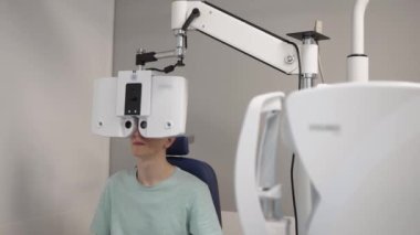 Lazer görüş düzeltmesi. Doktor modern göz hastalıkları ünitesini kullanarak hastanın gözlerini kontrol ediyor..