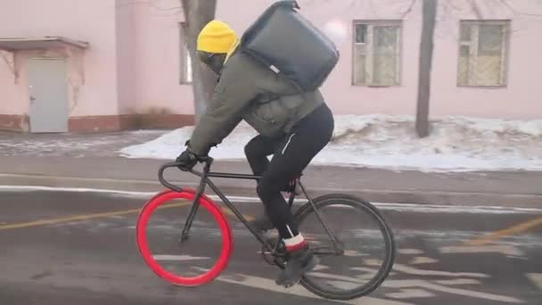 Rapaz de entrega com saco mais frio entregando a ordem de bicicleta com roda vermelha — Vídeo de Stock
