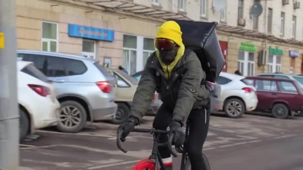 自転車のメッセンジャーは、道路に沿って彼の背中のドライブの後ろにクーラーバッグ — ストック動画
