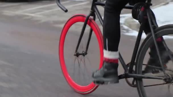 Professional cyclist rides fixed gear bike with red front wheel on an empty road — Stock Video