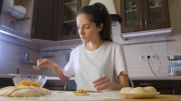 Mulher fazer uma torta de maçã na mesa de madeira com farinha e tortas de maçã perto — Vídeo de Stock