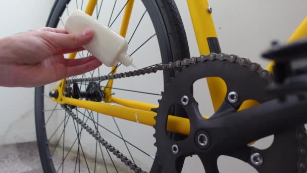 Man hand lubricates a bicycle chain with paraffin wax at home — Stok Video