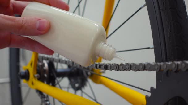 Man hand lubricates a bicycle chain with paraffin wax at home. Close up — стоковое видео