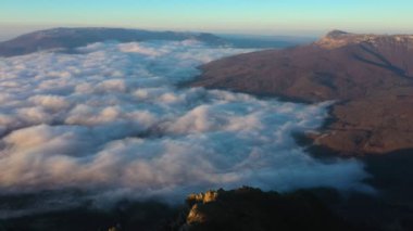 Drone shooting over the peak of Mount Demerdzhi and fly high above the clouds 