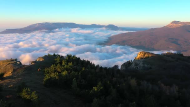 Drone tirant au-dessus du sommet de la montagne et voler haut au-dessus des nuages à l'aube — Video