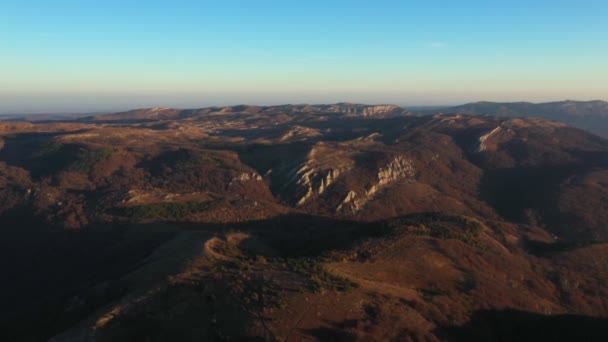 Drone survole un terrain montagneux en automne et se déplace vers le ciel bleu — Video