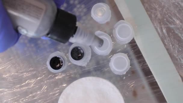 Tattoo artist in rubber gloves prepares the pigment for the tattoo machine — Stock video
