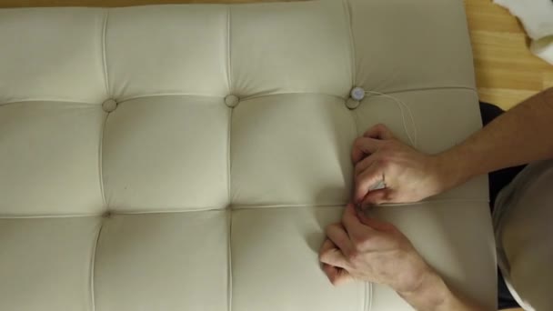 Letto imbottito mani Mans con nuovo tessuto e inserire pulsanti con ago da cucito — Video Stock