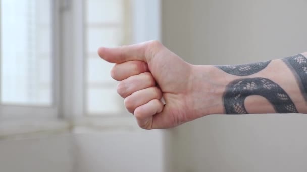 Mens hand with tattoo holds and breaks a large number of cigarettes in a fist — Stockvideo