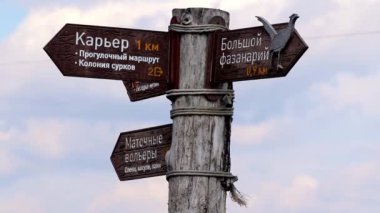Milli parkta rüzgarda sallanan yol tabelaları olan tahta bir direk.