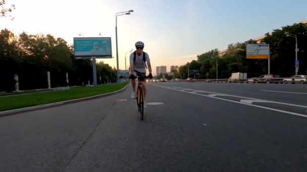 Ποδηλάτης βόλτες με ποδήλατο σε μια ελεύθερη εθνική οδό μεταξύ των αυτοκινήτων το καλοκαίρι. Προώθηση προβολής — Αρχείο Βίντεο