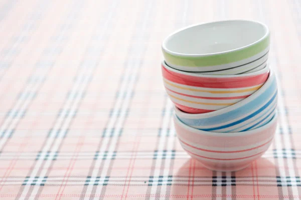 Stack of colorful bowls on fabric background — Stock Photo, Image