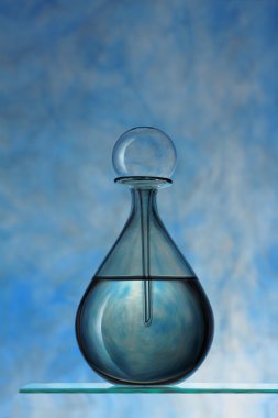 Mavi arka planda parfüm şişesi