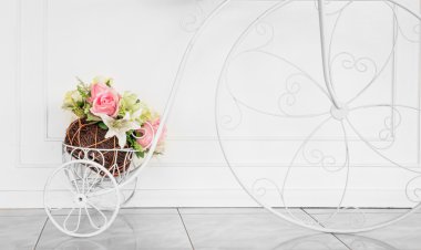 Yapay çiçek ile dekoratif bisiklet üzerinde beyaz duvar backgr