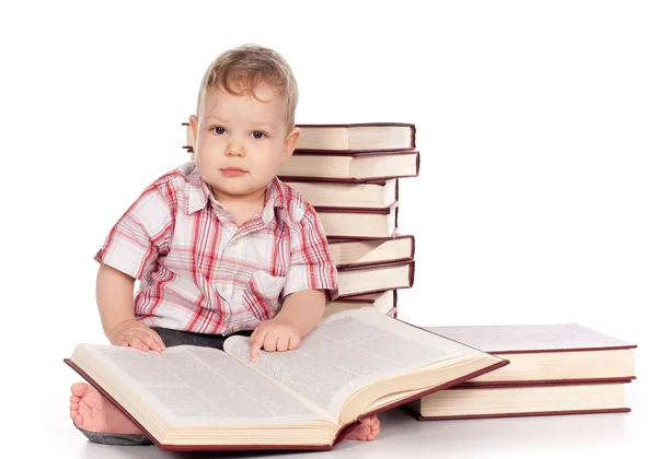 Niedliche kleine Junge mit vielen Büchern isoliert auf weiß — Stockfoto