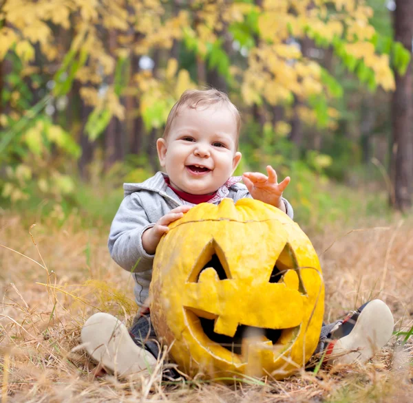 Baby boy outdoors with real pumpkin — Stock Photo, Image