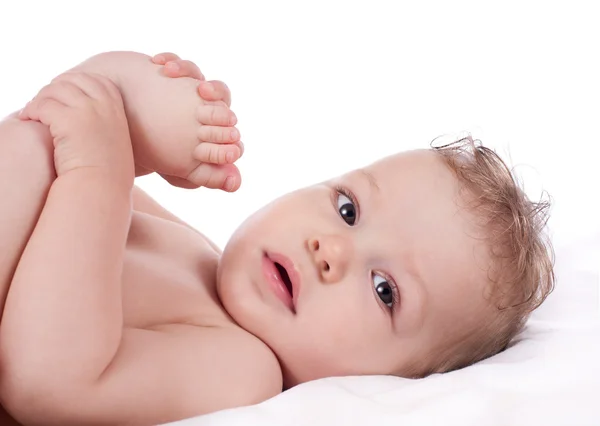 Closeup portret van babyjongen houden zijn voeten — Stockfoto