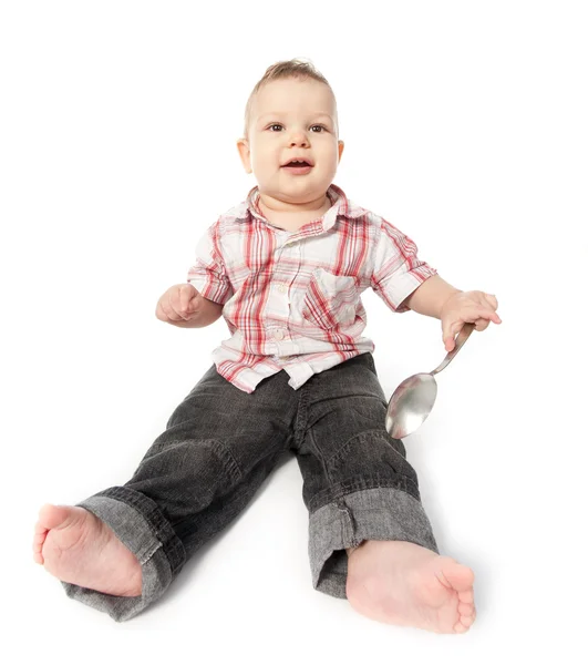 Groothoek schot van een babyjongen met grote lepel geïsoleerd op wit — Stockfoto