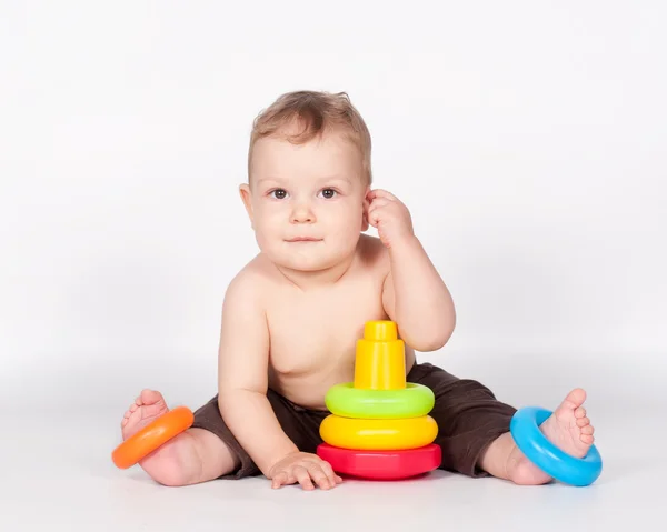 Baby boy playing with toy pyramid on white — Stock Photo, Image