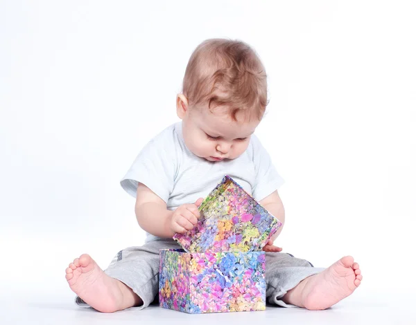 Baby Boy öffnet Geschenkbox auf weiß — Stockfoto