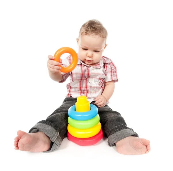 Baby boy playing with toy pyramid isolated on white Stock Picture