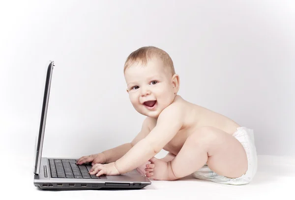 노트북을 가지고 있는 아기 스톡 사진
