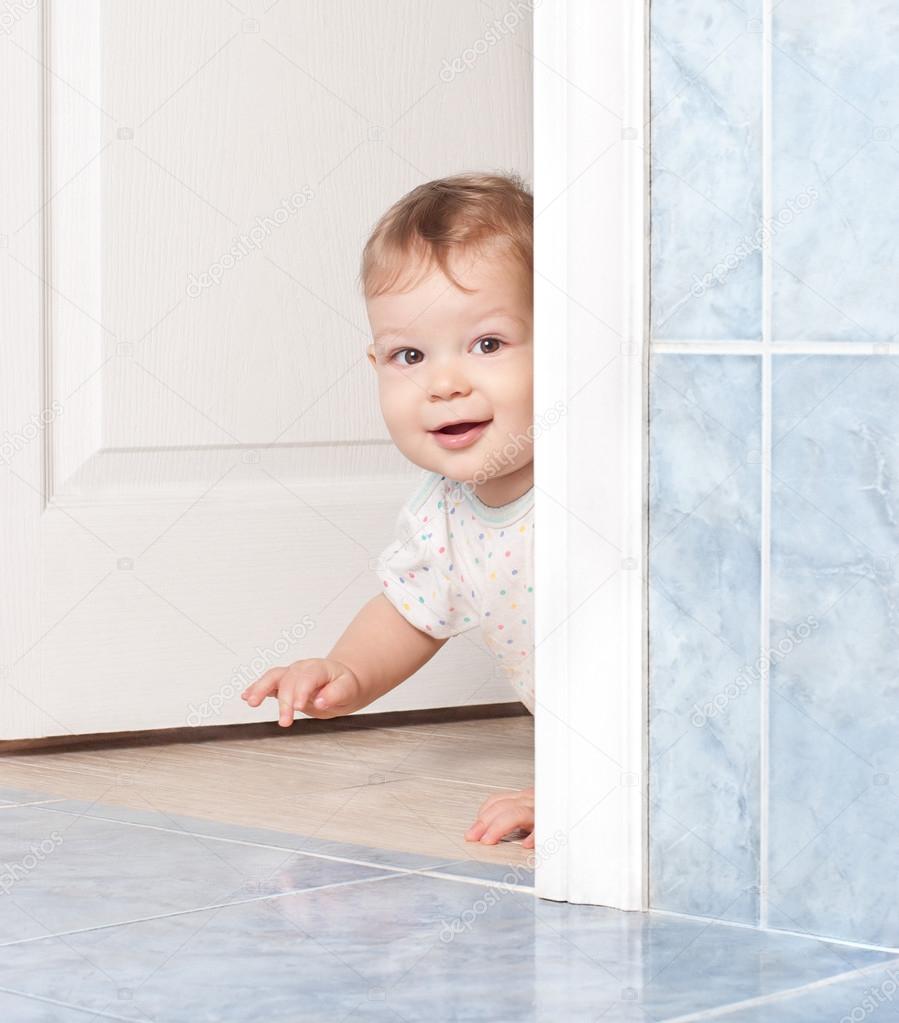 cute baby crawling through the door