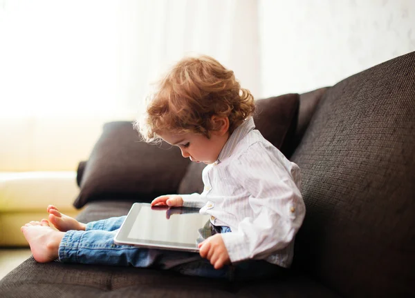 Little boy watching a movie on tablet, indoor