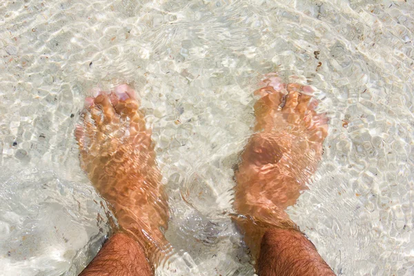 Pernas de homem em uma praia — Fotografia de Stock