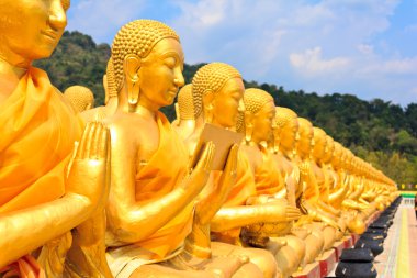 Tapınak mavi gökyüzünün altında birçok Buda heykeli