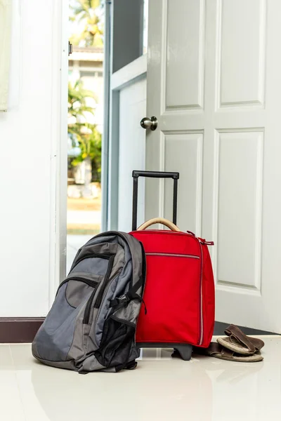 Kırmızı seyahat çantası, sırt çantası ve ayakkabı