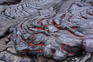 Lava flow cracks glowing in red