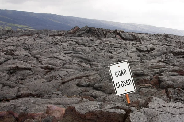 Señal de "carretera cerrada" en medio de un flujo de lava — Foto de Stock