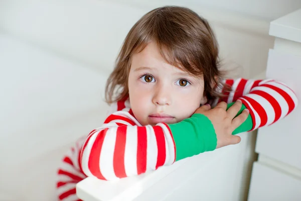 Retrato de menina pequena de pijama sentada na cama — Fotografia de Stock