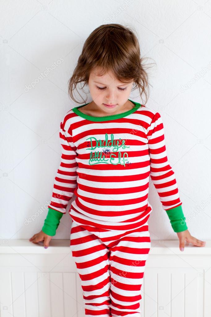 Small girl in striped pajamas sitting on her bed — Stock Photo © azaza