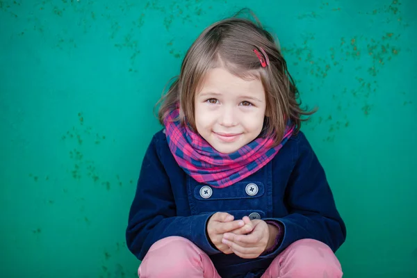 Portrait of preschooler girl sitting near wall — Stock Photo, Image