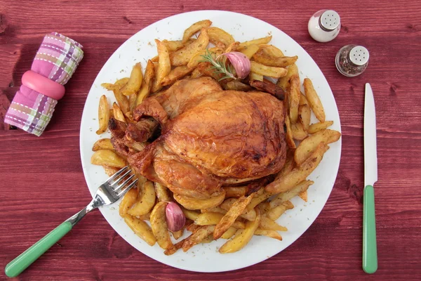 Roast chicken and potatoes on the rustic table — Stock Photo, Image