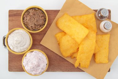 dilim kızarmış polenta beyaz masa üstünde sos ile