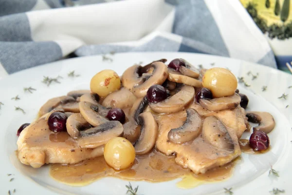 Carne con champiñones y uvas en el plato — Foto de Stock