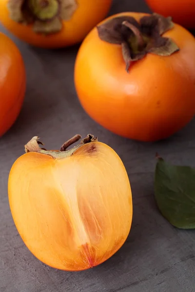 Trancher Persimmon sur la table grise — Photo